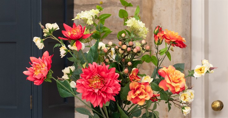 Cream, orange and red seasonal artificial flower arrangement