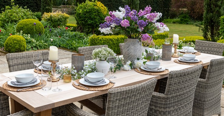 Outdoor dining tablescape with purple and white artificial flowers