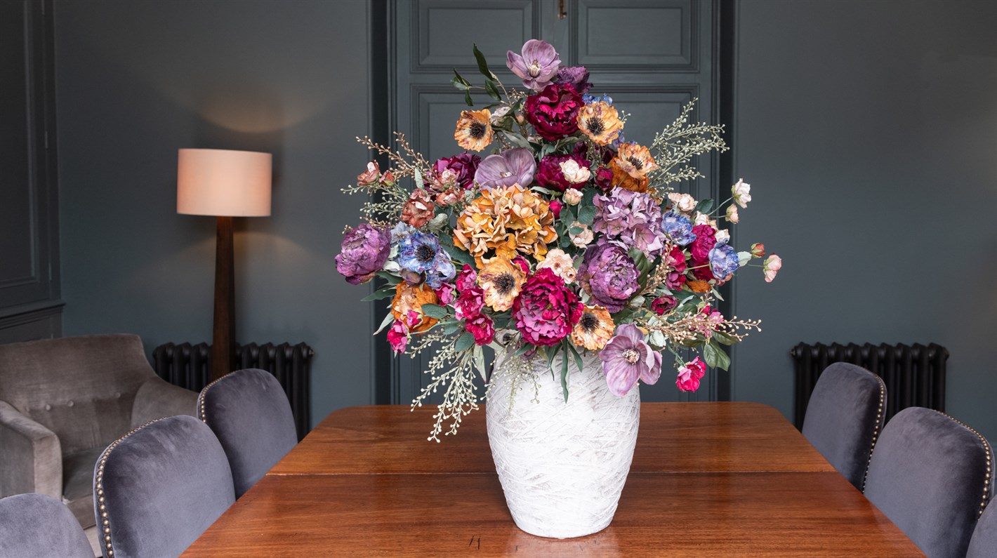 Large statement faux flower arrangement using sustainable stems in ceramic vase